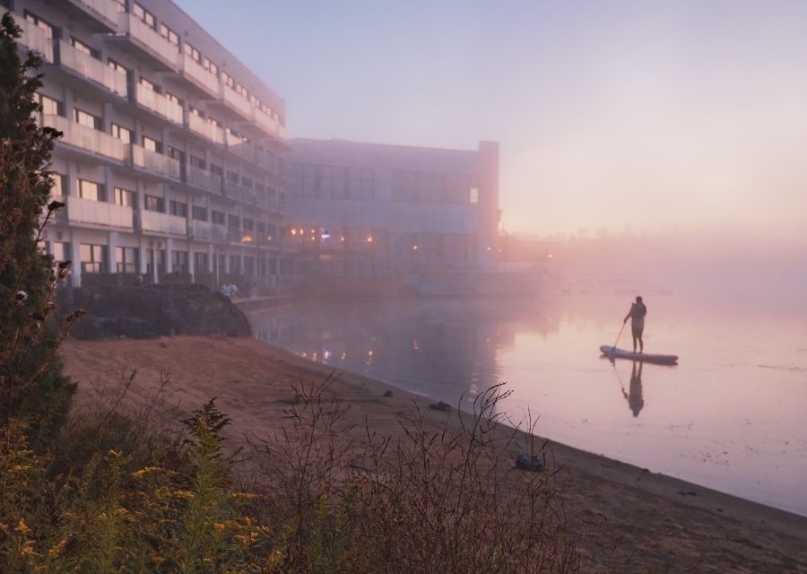 Personne en planche à pagaie sur le lac brumeux en septembre